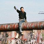 Photo de Peter Turnley montrant un jeune homme à cheval sur le mur de Berlin le 12 novembre 1989