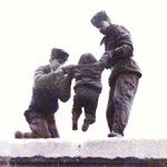 Gardes soulevant un enfant par dessus le mur de Berlin vers 1961